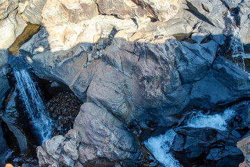 canyon with natural water potholes with clear mountain water and rocks out of focus with grain