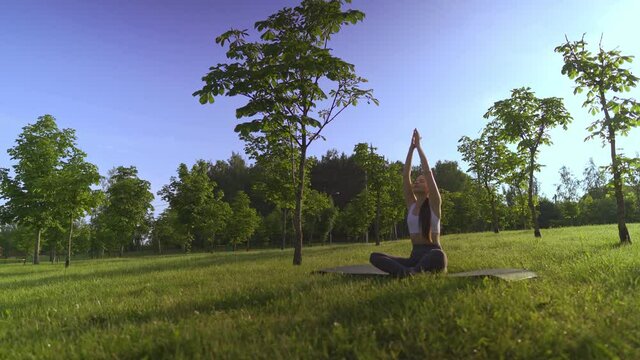 Young woman yoga outdoors keep calm and meditates while practicing yoga to explore the inner peace.