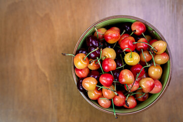 Cherry in a bowl on a wooden background
