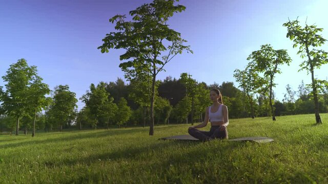 Young woman yoga outdoors keep calm and meditates while practicing yoga to explore the inner peace.