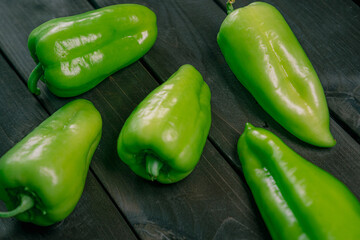 Green peppers on a wooden background