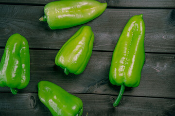 Green peppers on a wooden background