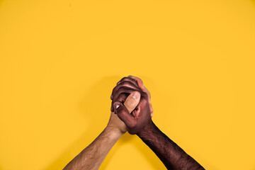 Multicultural hands united calling for freedom and equality on a yellow background. African and...
