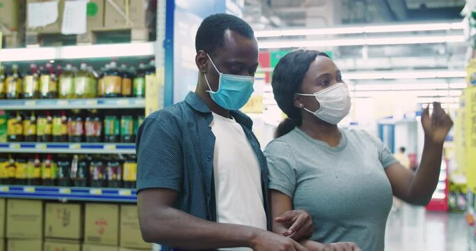 Black couple shopping in the supermarket with mask during Covid-19 Coronavirus pandemic in 2020 African people wear face mask buying food in the market