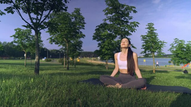 Young woman yoga outdoors keep calm and meditates while practicing yoga to explore the inner peace.