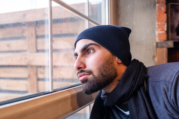 Arabic muslim man looking from window feeling sad