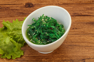 Obraz na płótnie Canvas Green Chuka Seaweed Salad Isolated on White Background Top View. Wakame Sea Kelp Salat
