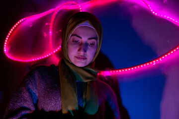 Arabic muslim girl with beatiful colored lights  behind her