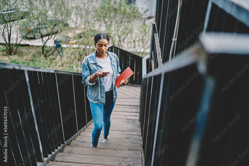 Aufkleber pensive african american young woman with red textbook in hands while reading received notification 