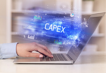 Closeup of businessman hands working on laptop with CAPEX inscription, succesfull business concept