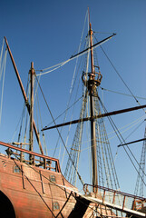 Vista lateral e de parte da popa de um navio pirata com as velas recolhidas, mastro principal com...