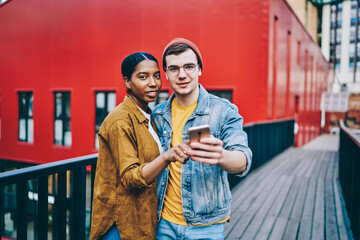 Half length portrait of good looking millennial dressed in trendy streetwear standing at urbanity...