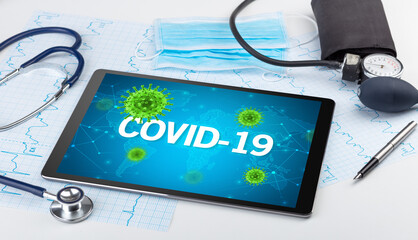 Close-up view of a tablet pc with COVID-19 inscription, microbiology concept