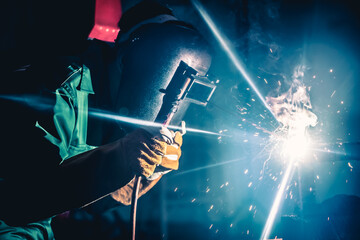 Metal welding steel works using electric arc welding machine to weld steel at factory. Metalwork...