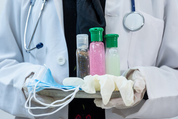 Arabic muslim doctor wearing mask and presenting hygiene and protection products