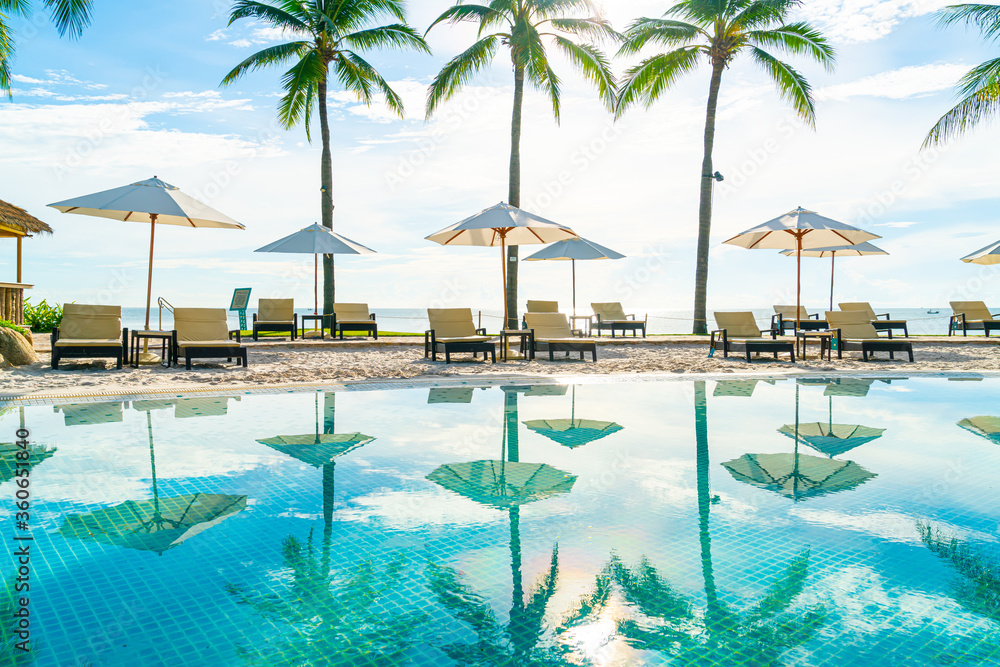 Wall mural beautiful umbrella and chair around swimming pool in hotel and resort