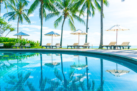 Beautiful umbrella and chair around swimming pool in hotel and resort