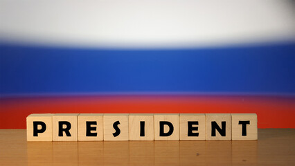 Russia PRESIDENT message word on a wooden desk on cube blocks with a Russia flag background