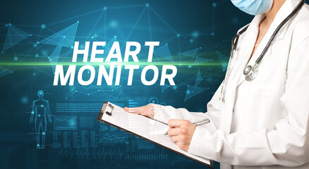 doctor writes notes on the clipboard with HEART MONITOR inscription, medical diagnosis concept