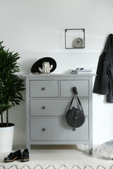 Grey chest of drawers in stylish room. Interior design