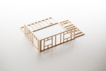 Building a house or a home. Frame work of a house (miniature model) isolated on neutral white with natural shadows.