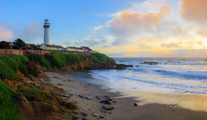 Fototapeta na wymiar Pastel colors of sunset and silky water from long exposure of waves crashing by Pigeon Point Lighthouse on Northern California Pacific Ocean coastline at sunset