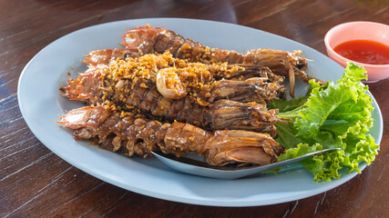 stir-fired mantis shrimp dish on wooden table at restaurant in thailand 