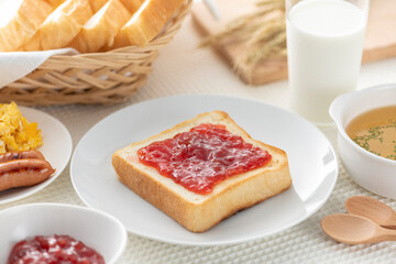 食卓に並んだ食パン（苺ジャム）