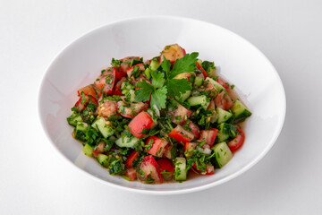 Salad of tomatoes, cucumber, sweet pepper and finely chopped greens with sauce top view. Dishes for delivery, online store. Isolated on a white background.