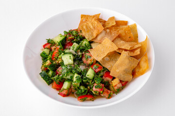 Salad of tomatoes, cucumber, sweet pepper and finely chopped herbs with sauce and chips top view. Dishes for delivery, online store. Isolated on a white background.