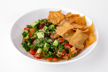 Salad of tomatoes, cucumber, sweet pepper and finely chopped herbs with sauce and chips top view. Dishes for delivery, online store. Isolated on a white background.