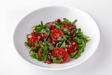 Salad of arugula, cherry tomatoes, pomegranate and sauce top view. Dishes for delivery, online store. Isolated on a white background.