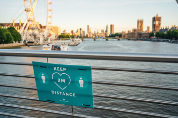 London / UK - 06/06/2020: Keep 2 meter distance on the bridge with Big Ben and London Eye background