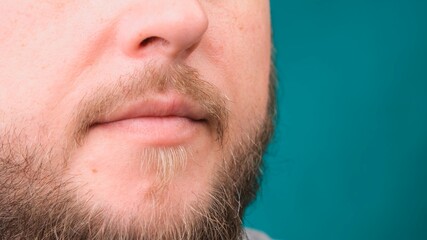 Obraz premium Close up of male bearded face and mouth on green screen, copy space.