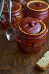 Homemade food. Potatoes and fish in clay pots on a wooden table