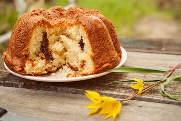 Homemade cupcake with chocolate filling inside on a wooden table with a Yellow Woodland tulips, Wild tulips on a wooden background. Close-up.