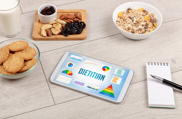 Organic food and tablet pc showing DIETITIAN inscription, healthy nutrition composition