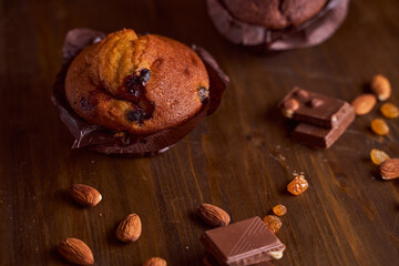 Chocolate maffin on a wooden table with chocolate and tartallini