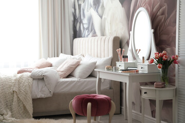 Stylish bedroom interior with elegant dressing table and floral wallpaper