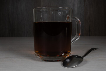 Glass cup with tea on a dark background.