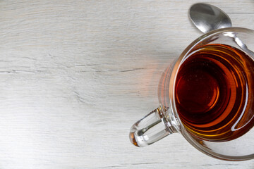 Glass transparent cup with black tea with a top view.