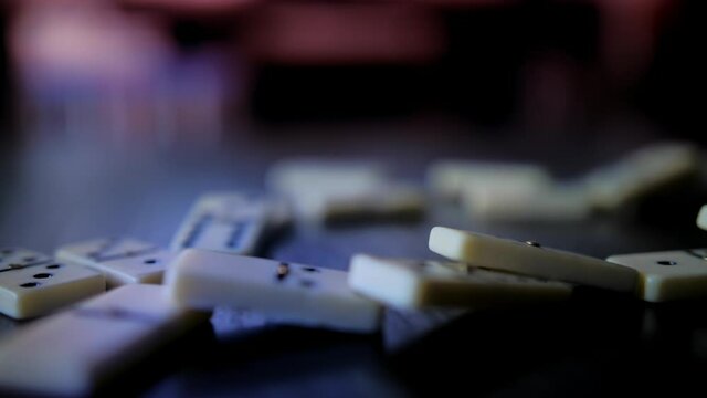 Domino slowly falling on a wooden table shot in slow motion
