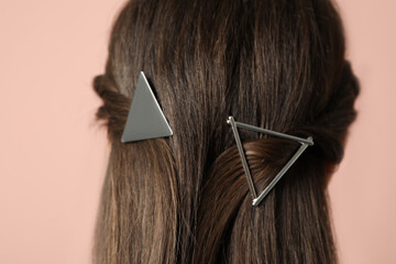 Woman with beautiful hair clips on pink background, closeup