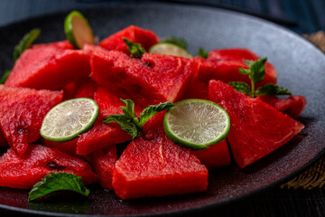 fresh watermelon salad kept in a black plate on dark background
