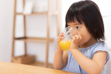 オレンジジュースを飲む子供