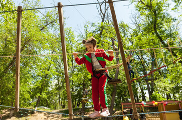 Girl climbing in high rope course enjoying the adventure