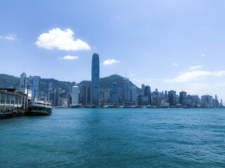 Skyline and ferry pier of Hong Kong, in a sunny morning.