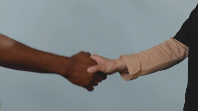 Close up white and black men shake hands stop racism all people are equal togetherness symbol tolerance multiracial peace interracial friendship anti-racism slow motion