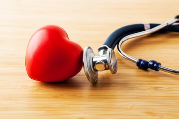 Healthcare and medical concept. Stethoscope and red heart on wooden table.
