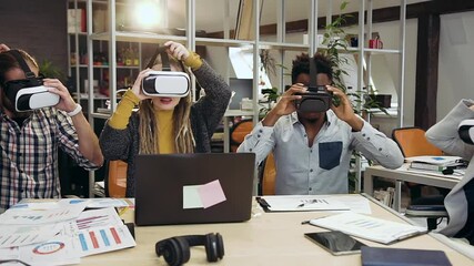 Close up of attractive satisfied creative international workteam which working in virtual reality headset in contemporary office - Powered by Adobe